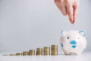 Persona depositando dinero en una hucha